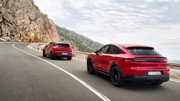 Vista dinámica de dos Porsche Cayenne GTS 2024 en carretera montañosa