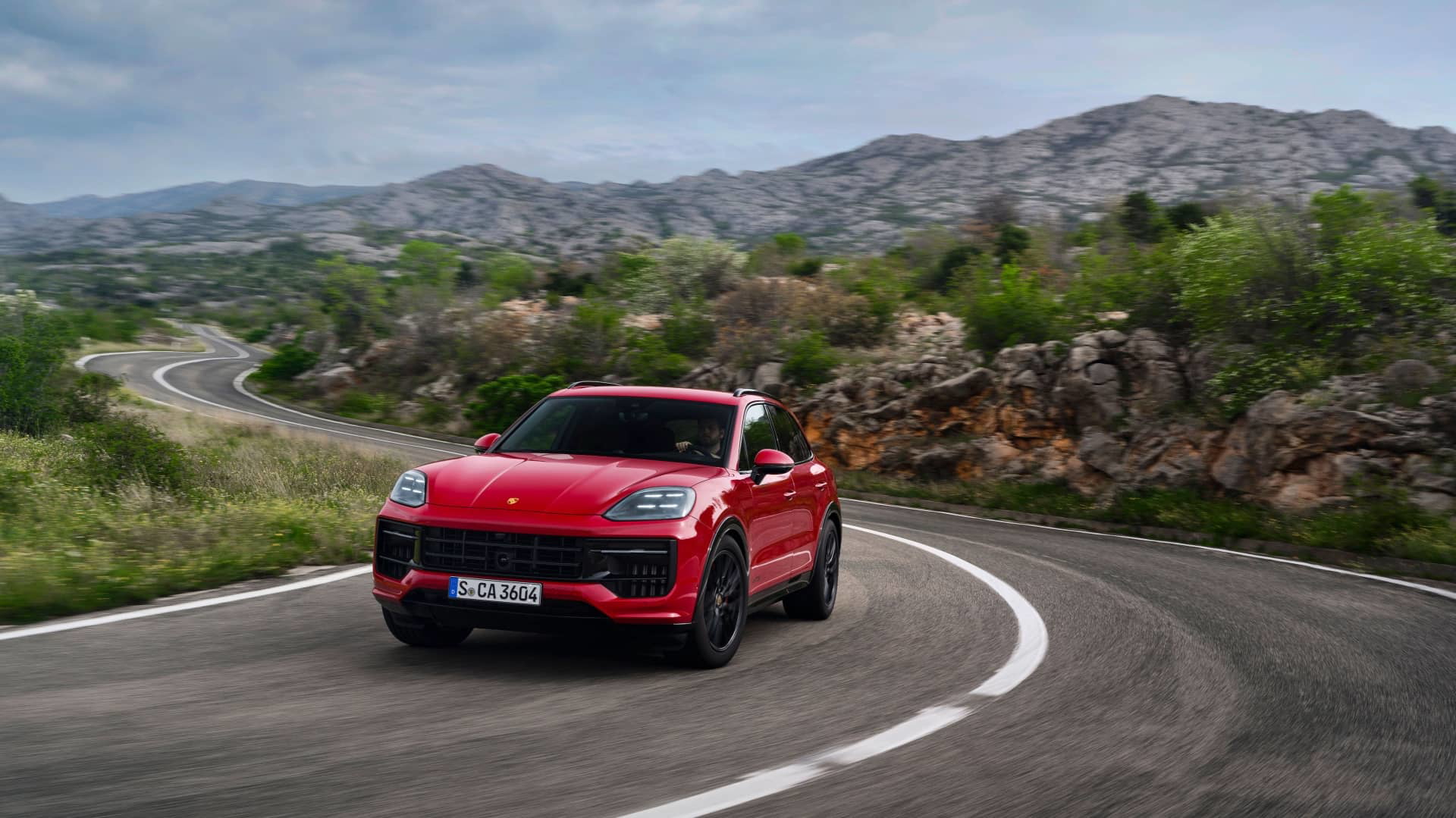 Vista dinámica del Porsche Cayenne GTS 2024 en carretera abierta.