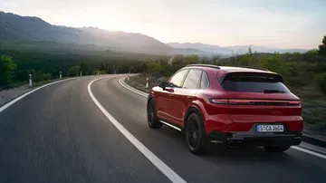 Vista dinámica del Porsche Cayenne GTS 2024 en carretera abierta.
