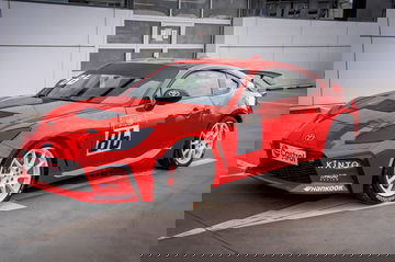 Vista lateral del Toyota GR86 en pista, luciendo librea de competición.