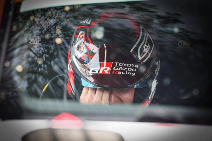 Piloto enfocado en la estrategia de carrera, casco Toyota Gazoo Racing visible.
