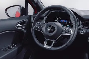 Vista detallada del puesto de conducción del Renault Captur 2024, destacando su volante y cuadro de instrumentos.