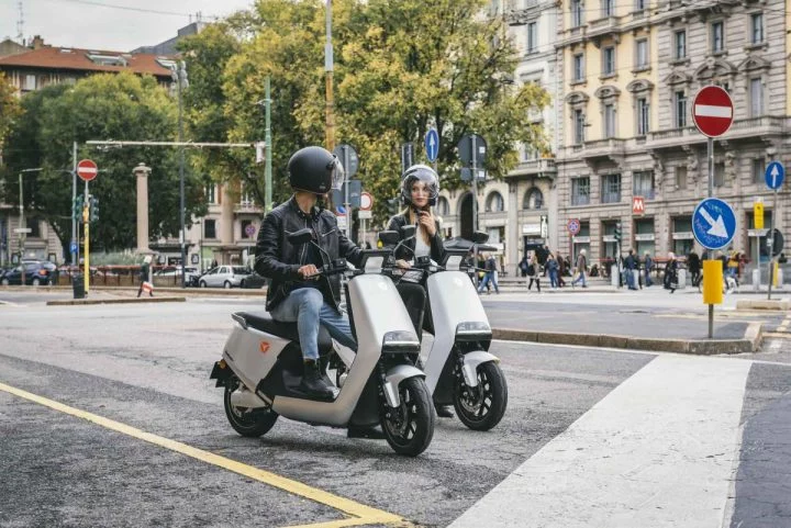 Dos scooters eléctricos Yadea circulando en entorno urbano.