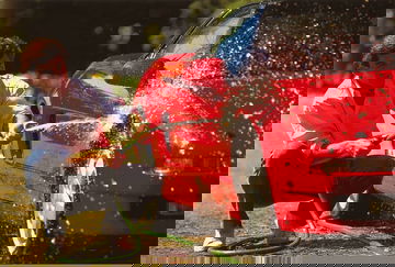 Imagen de Ayrton Senna lavando un Honda NSX rojo, destacando la figura del deportivo.