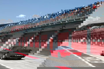Homenaje a Senna con un deportivo clásico en el pitlane. Colores y diseño icónicos.