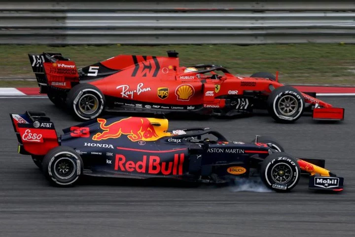 Dos monoplazas de Fórmula 1 en plena competencia en circuito.