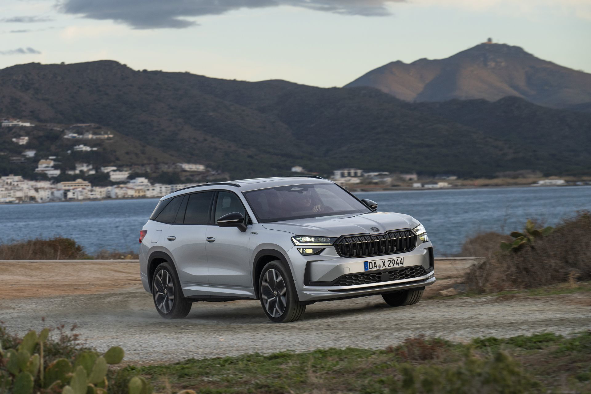Vista lateral del Škoda Kodiaq 2024 conduciendo por un camino costero.