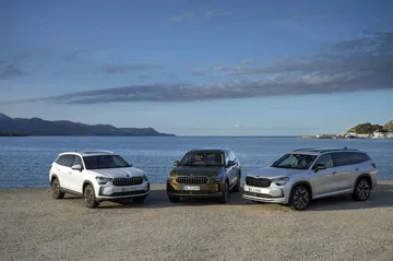 Vista frontal y lateral de la gama Skoda Kodiaq 2024 estacionados frente al mar.