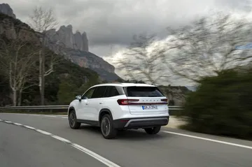 Vista dinámica del Skoda Kodiaq 2024 en carretera, destacando su diseño trasero y lateral.