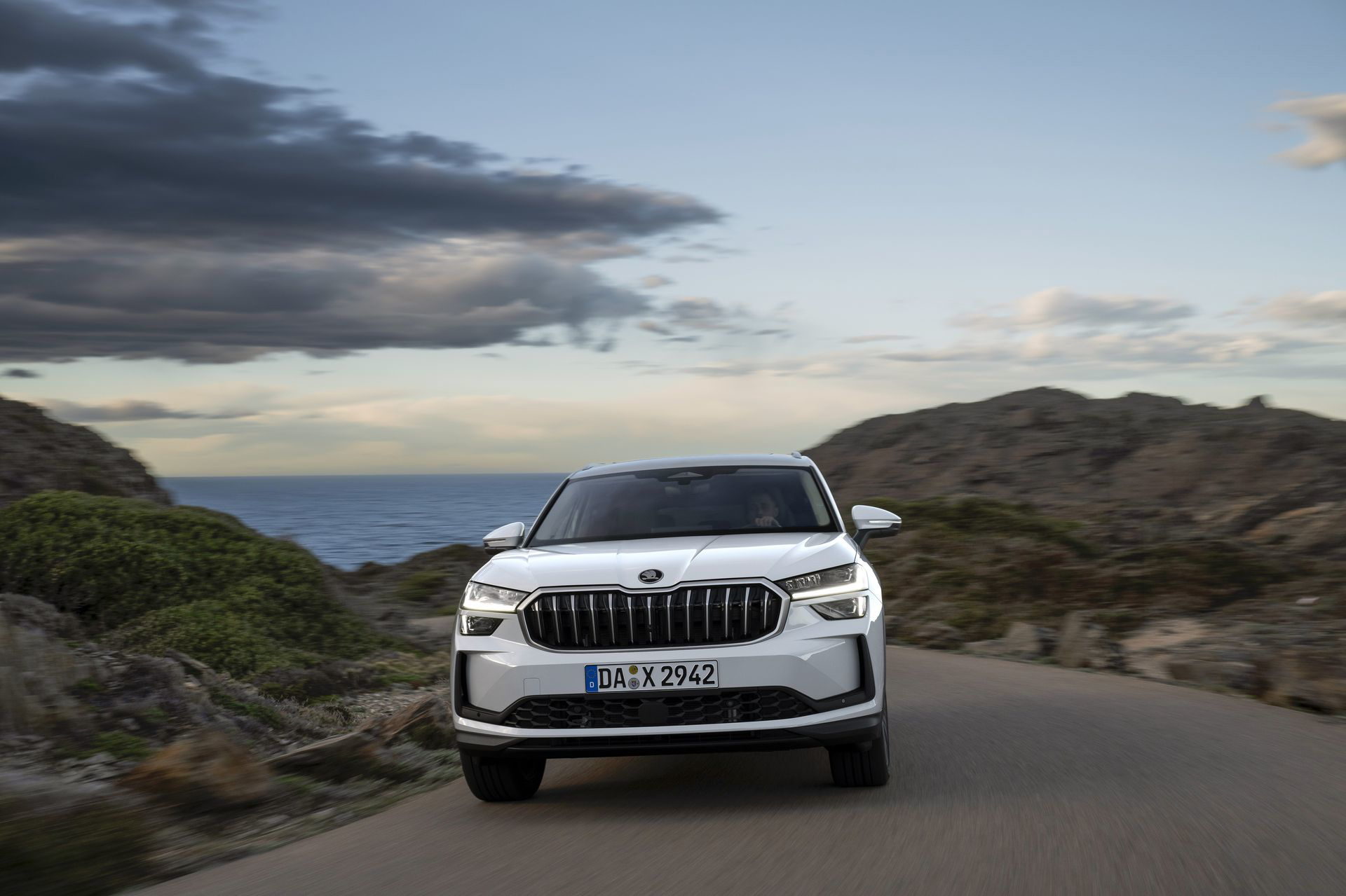 Vista frontal del Škoda Kodiaq 2024 en movimiento, destacando su parrilla y faros.