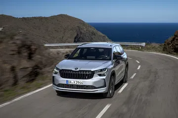 Vista dinámica del Škoda Kodiaq 2024 rodando por carretera costera.
