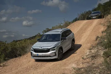 Vista lateral del Škoda Kodiaq 2024 circulando por camino de tierra