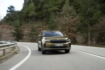 Vista dinámica del Škoda Kodiaq 2024 rodando en carretera serpenteante.