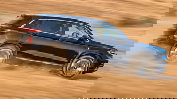 SUV mostrando su capacidad en terreno arenoso, destacando líneas dinámicas.