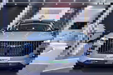 Vista frontal de un SUV de lujo con parrilla cromada y faros LED en exposición.