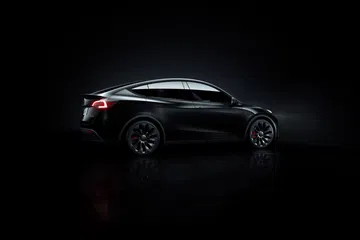 Vista lateral del Tesla Model Y 2024, mostrando su diseño aerodinámico y líneas modernas.