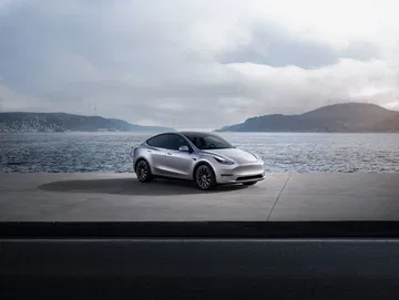 Vista lateral del Tesla Model Y 2024 destacando su diseño aerodinámico y moderno.
