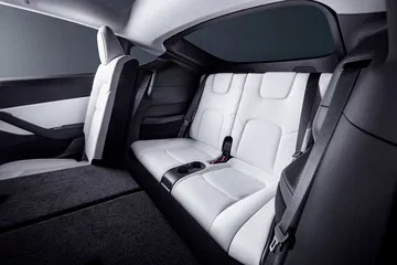 Vista lateral trasera del habitáculo del Tesla Model Y 2024, destacando su diseño minimalista y acabados premium.