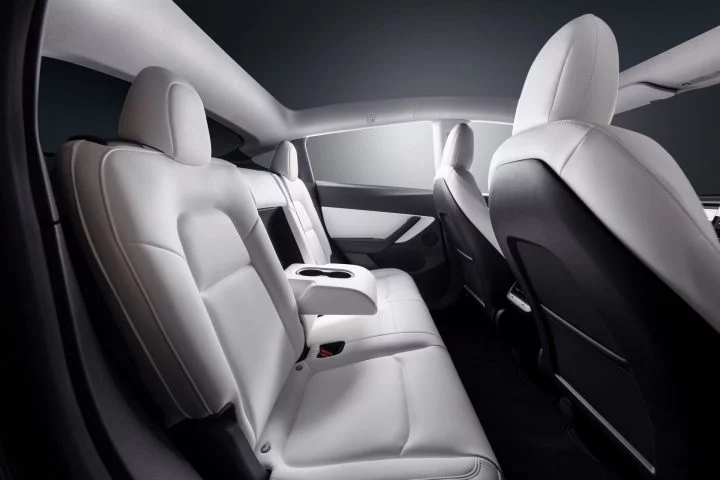 Vista lateral de los asientos en cuero claro del Tesla Model Y 2024, destacando su diseño y acabados.