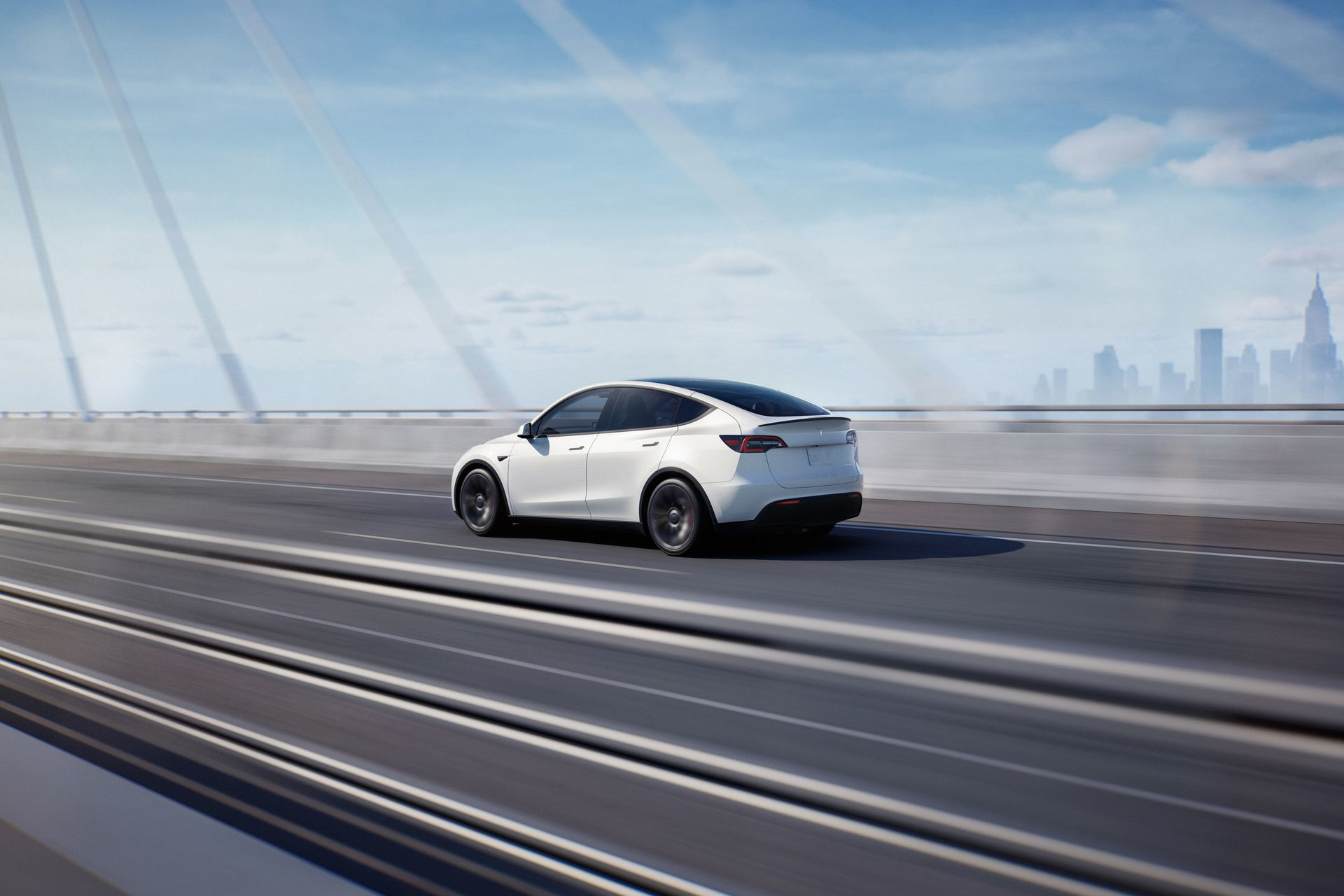 Vista dinámica lateral del Tesla Model Y, destacando su diseño aerodinámico y moderno.