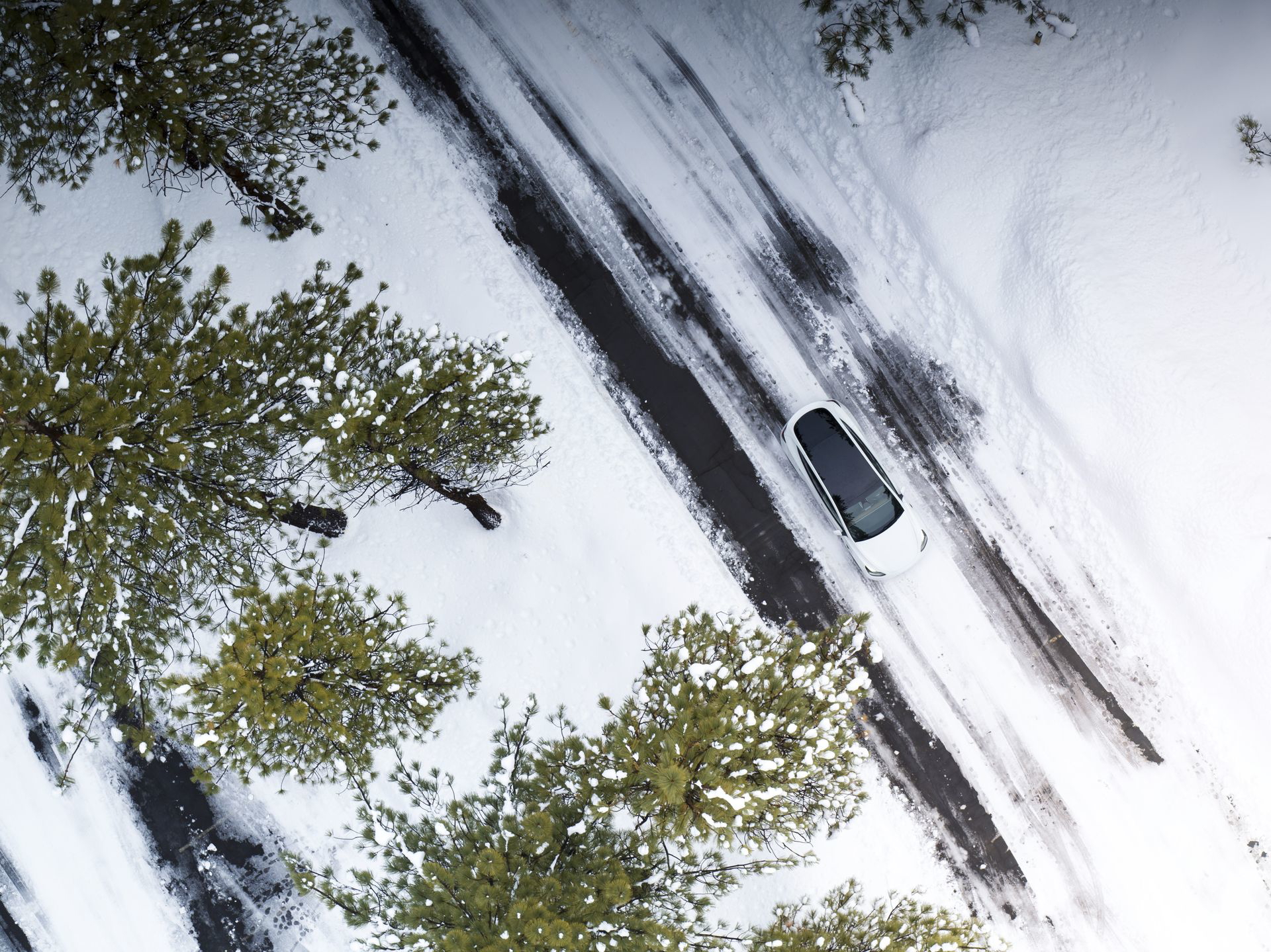 Vista aérea de un Tesla Model Y 2024 destacando su techo y entorno invernal.