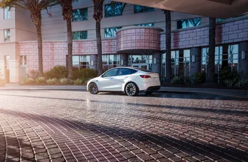 Vista trasera y lateral de un Tesla Model Y, mostrando su diseño y líneas aerodinámicas.