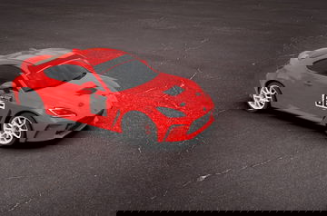 Vista lateral del Toyota 86 en color rojo destacando su diseño deportivo y dinámico.
