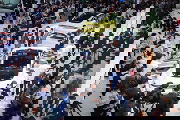 Vista aérea de un vehículo descapotable rodeado de público en un evento de motor.