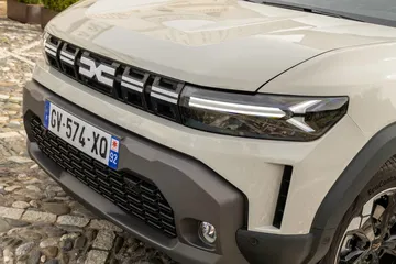Vista frontal parcial del Dacia Duster, destacando su robusta parrilla.