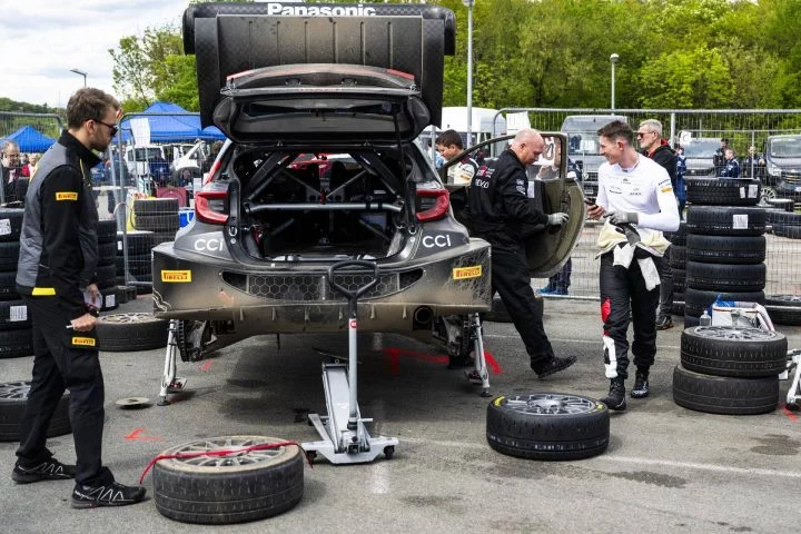 Vista de un WRC en zona de asistencia, con mecánicos preparando la estrategia de neumáticos.