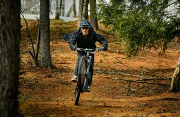 Ciclista maniobrando una ebike a través de terreno forestal