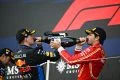 Dos pilotos de F1 celebrando en el podio, botella de champán en mano