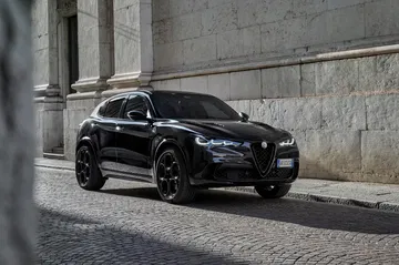 Vista lateral Alfa Romeo Stelvio Quadrifoglio, distinguiéndose por su diseño deportivo.