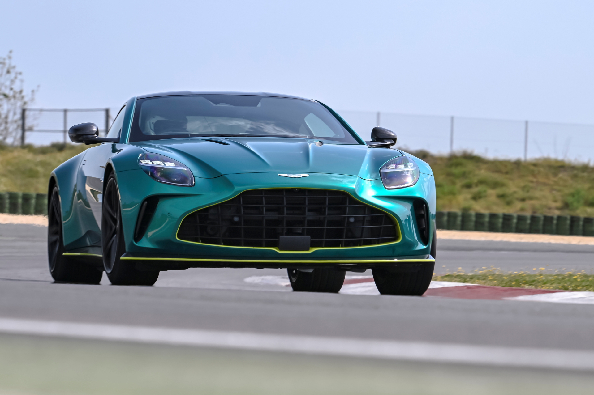 Vista dinámica del Aston Martin Vantage 2024 en pista, mostrando su perfil y frontal agresivo.