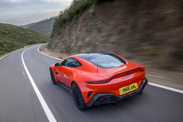 Vista dinámica del Aston Martin Vantage 2024 en una carretera montañosa.