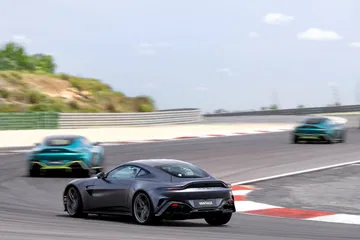 Vista dinámica del Aston Martin Vantage 2024 en pista, destacando su perfil y diseño.