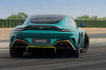 Vista trasera y lateral del Aston Martin Vantage 2024 en movimiento.
