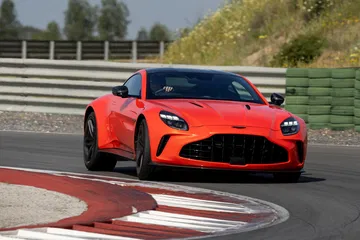 Vista dinámica del Aston Martin Vantage 2024 abordando una curva en circuito.