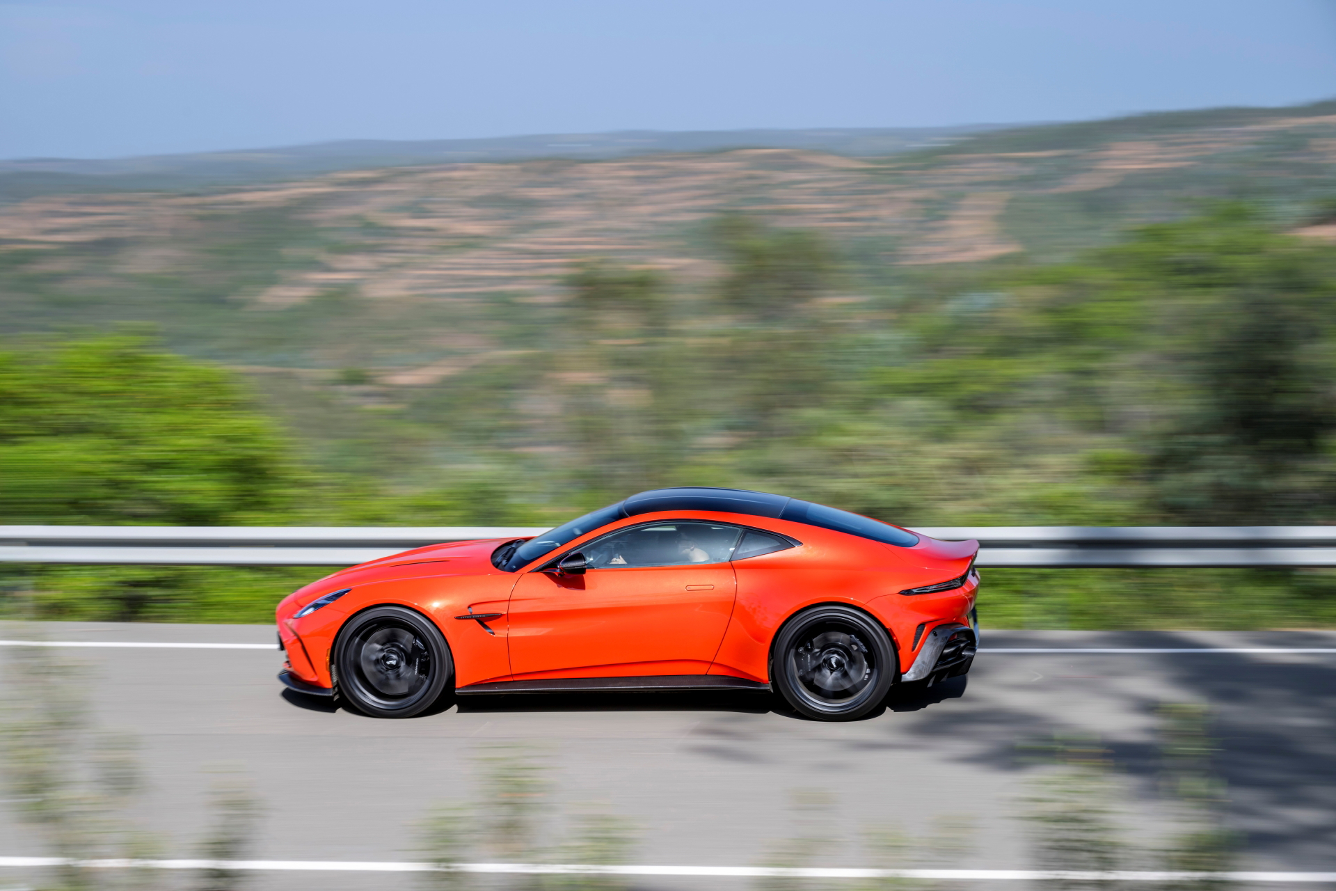 Vista dinámica del Aston Martin Vantage 2024 en carretera abierta.