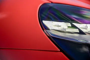 Primer plano del faro del Aston Martin Vantage 2024, diseño vanguardista y elegante.