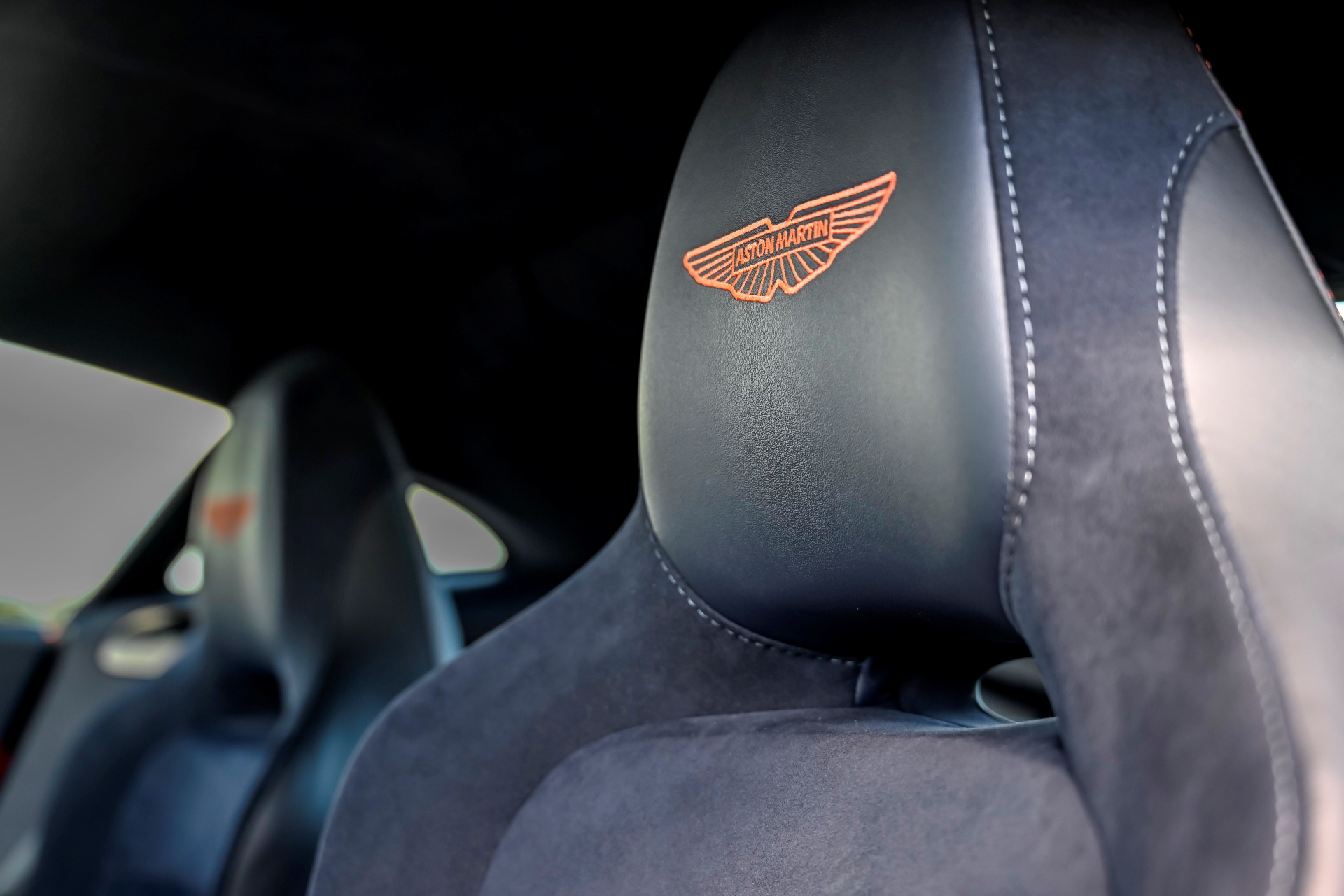 Exquisitos asientos deportivos con emblema Aston Martin en relieve.