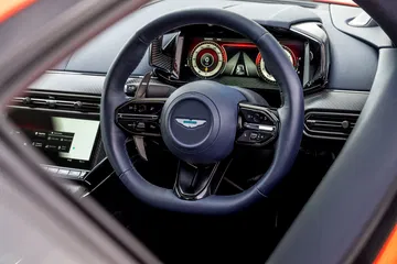 Volante de cuero con emblema de Aston Martin, reflejo de lujo y deportividad.