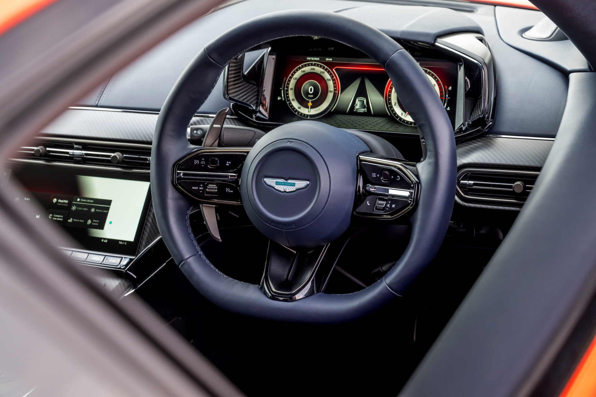 Volante de cuero con emblema de Aston Martin, reflejo de lujo y deportividad.