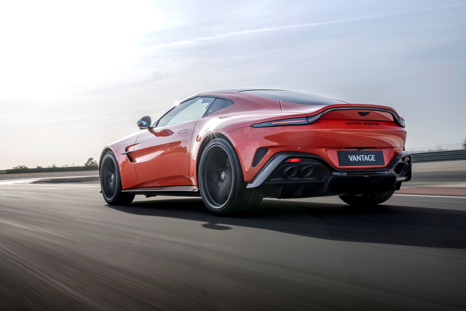 Vista dinámica del Aston Martin Vantage 2024 con enfoque en su perfil trasero.