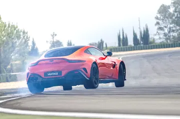 Vista dinámica del Aston Martin Vantage 2024 mostrando su línea trasera y lateral.