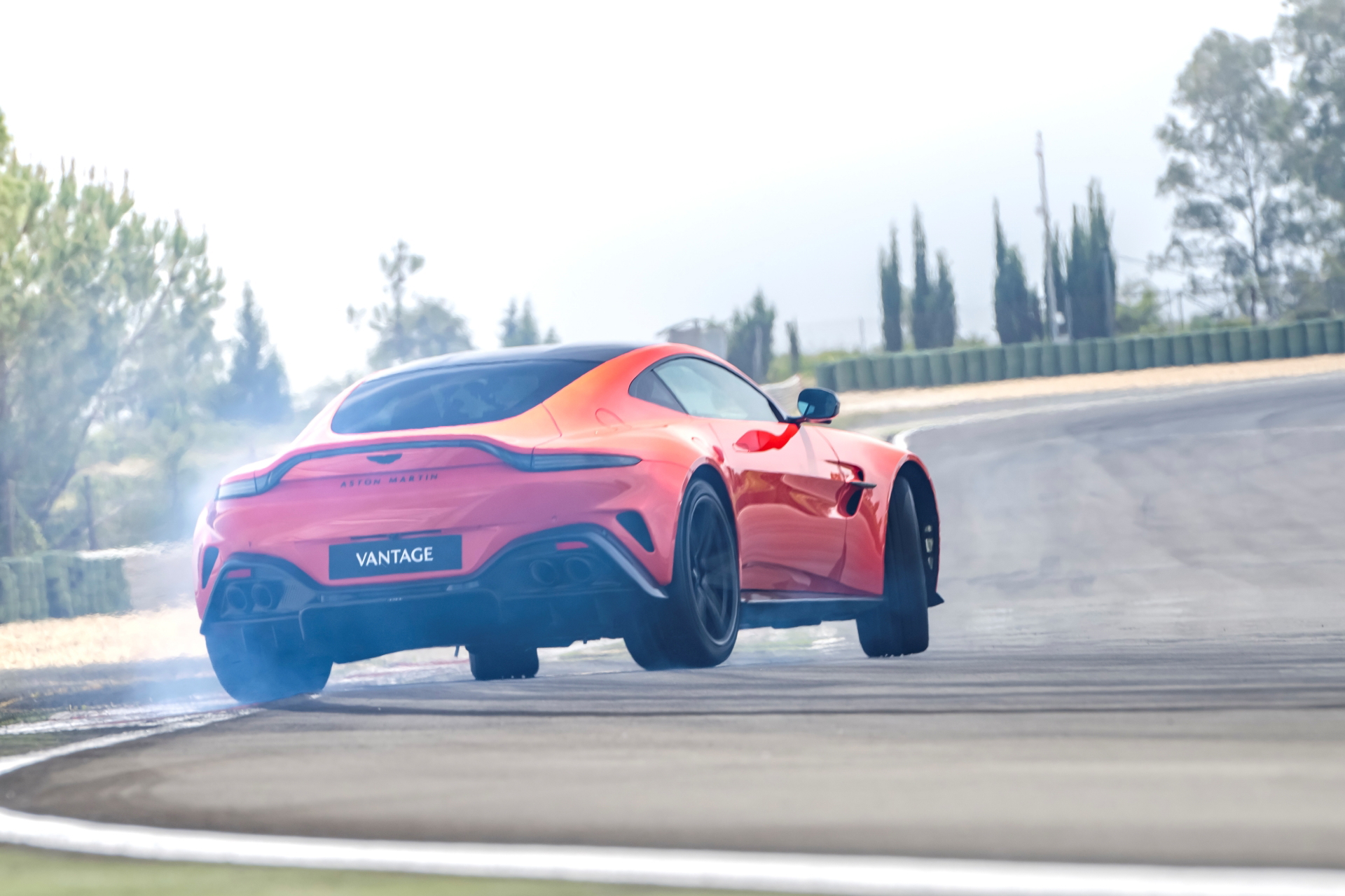 Vista dinámica del Aston Martin Vantage 2024 mostrando su línea trasera y lateral.