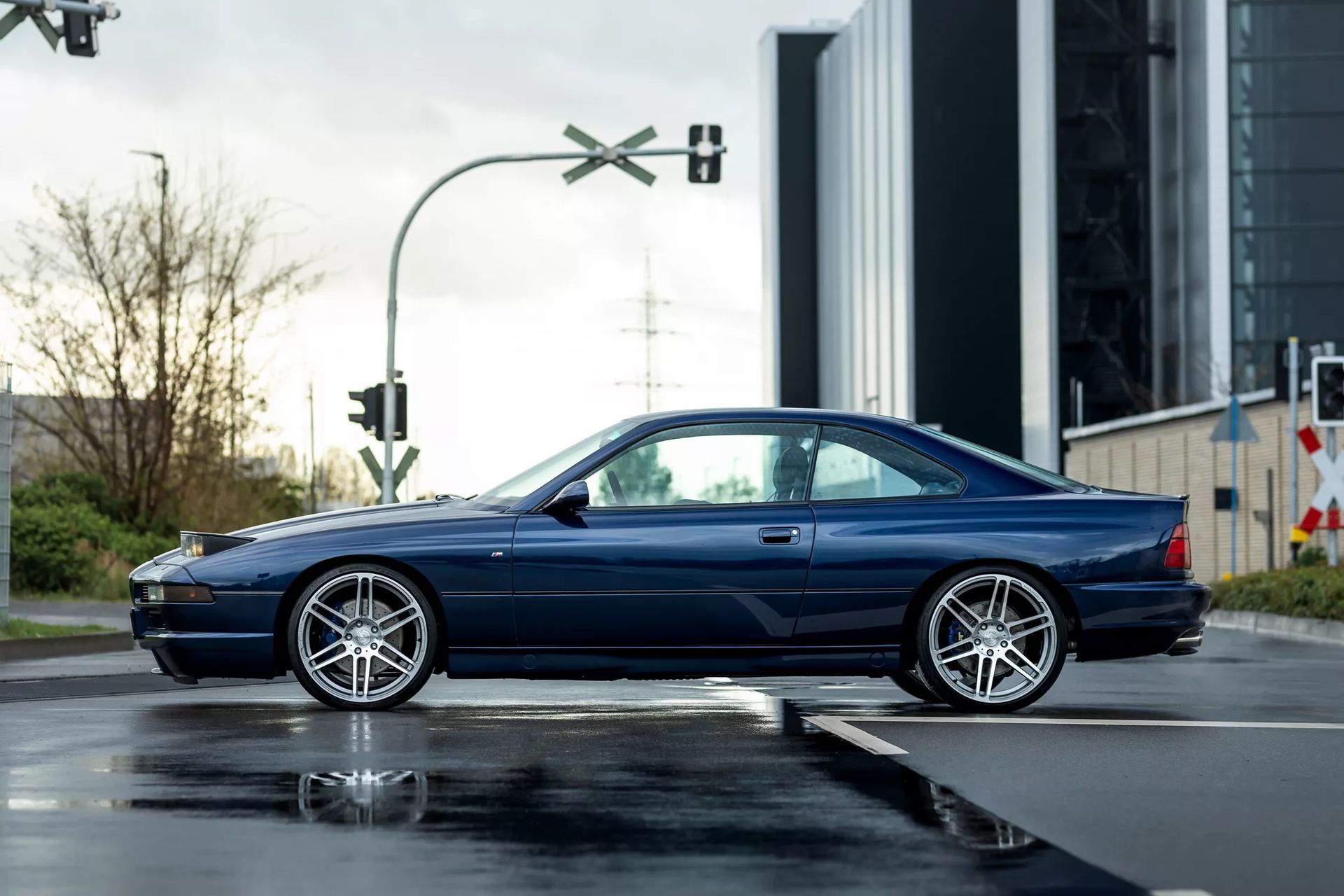 Vista lateral de un impecable BMW Serie 8 con llantas pulidas.