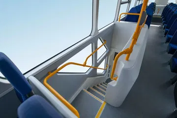 Vista lateral de las escaleras y asientos en el segundo piso de un autobús BYD