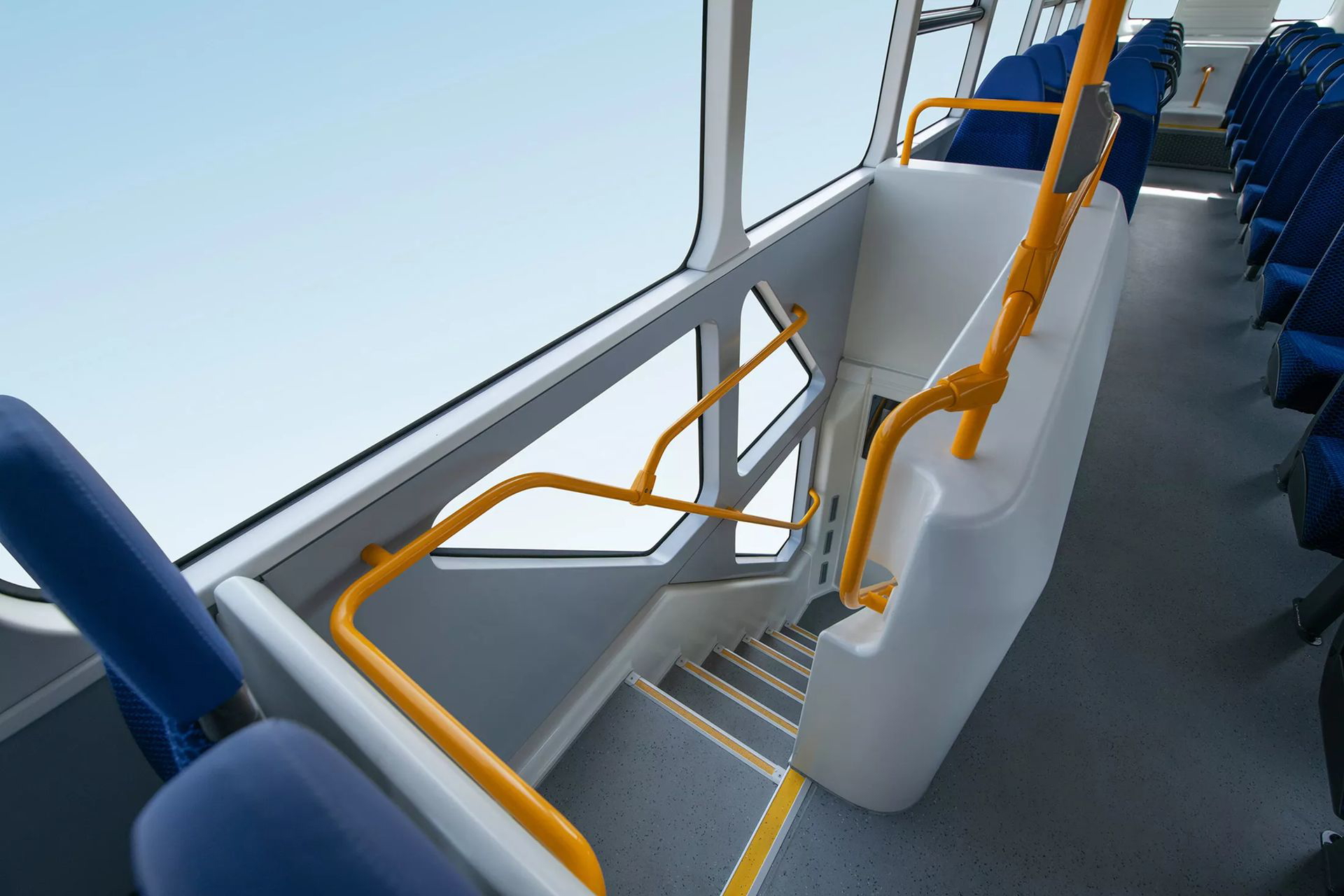 Vista lateral de las escaleras y asientos en el segundo piso de un autobús BYD