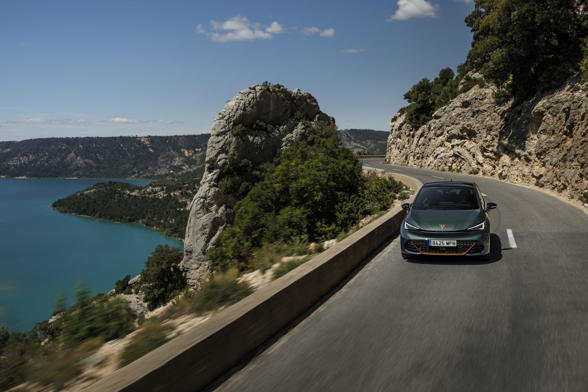 Vista dinámica del Cupra Born VZ en carretera con paisaje al fondo.